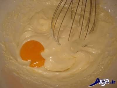 افزدن تخم مرغ به صورت تکی تکی به مایه شیرینی کوکی