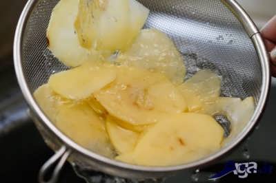 شستن ورقه های سیب زمینی برای تهیه چیپس خانگی 