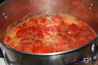 تقسیم کردن گوجه ها به 4 قسمت و قرار دادن آن ها در درون قابلمه 