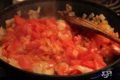 اضافه کردن گوجه به مخلوط سیر و پیاز