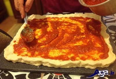مالیدن سس قرمز بر روی خمیر پیتزا 