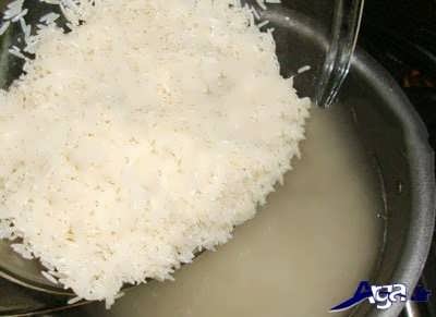 ریختن برنج در درون قابلمه 