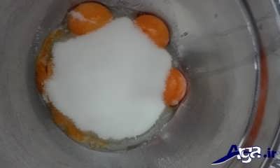 اضافه کردن شکر و وانیل به زرده تخم مرغ 