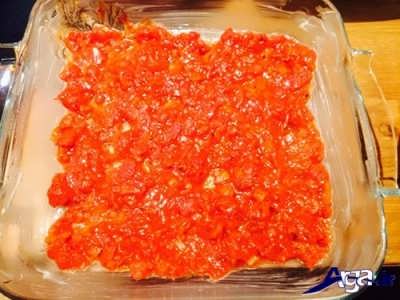 ریختن سس گوجه فرنگی در ته قالب فر 