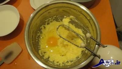 اضافه کردن تخم مرغ به مخلوط کره و شکر 