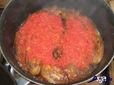 اضافه کردن بادمجان ها به مخلوط گوجه رنده شده و رب 