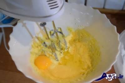اضافه کردن تخم مرغ به مخلوط شکر و کره 