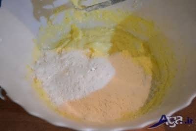 اضافه کردن آرد به مخلوط شکر و کره و زرده تخم مرغ 