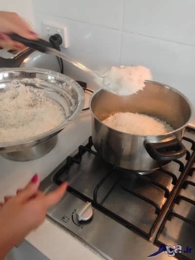 ریختن برنج آبکش در درون قابلمه 