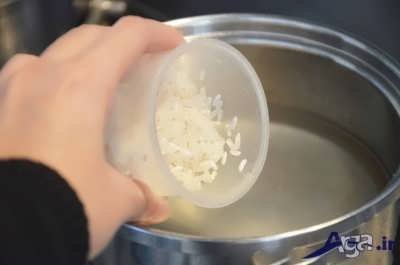 قرار دا ن برنج به همراه آب و نمک در درون قابلمه برای طرز تهیه برنج کته 