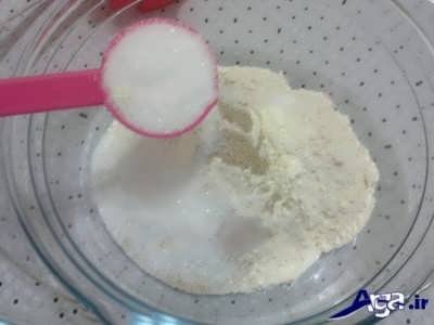 مخلوط کردن پودر شیر خشک با شکر و خمیر مایه و آرد سفید 