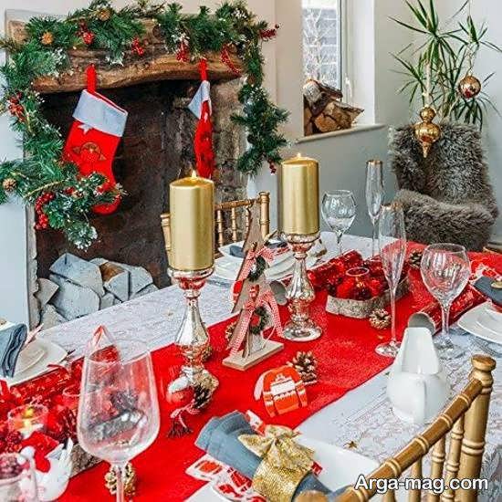 زیباسازی میز کریسمس با استفاده از نمادهای کریسمس مانند درخت سرو و بابا نوئل
